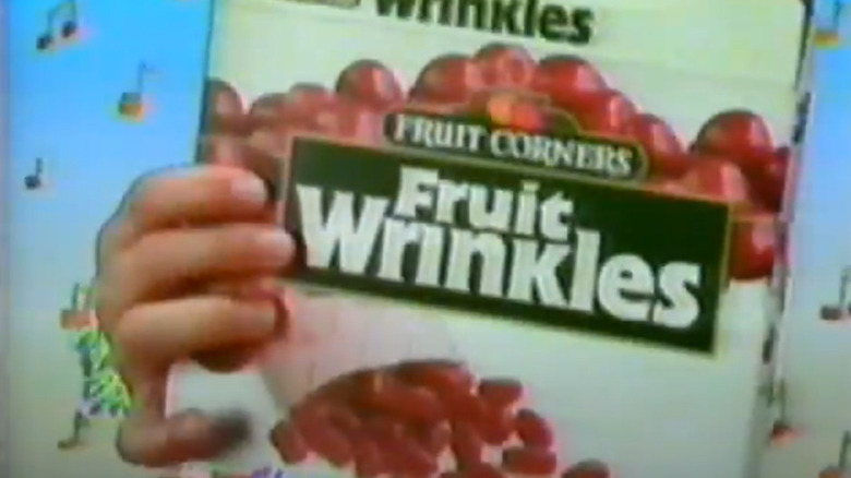 Grainy screenshot of a hand holding a box of Fruit Wrinkles