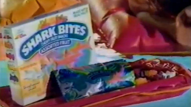 Screenshot of '90s ad for Shark Bites, featuring box and gummies on pool floatie
