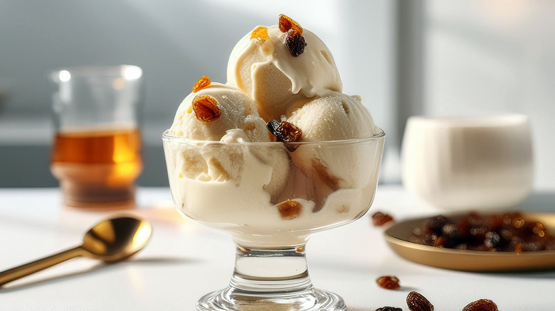 A glass bowl containing three scoops of Rum Raisin ice cream