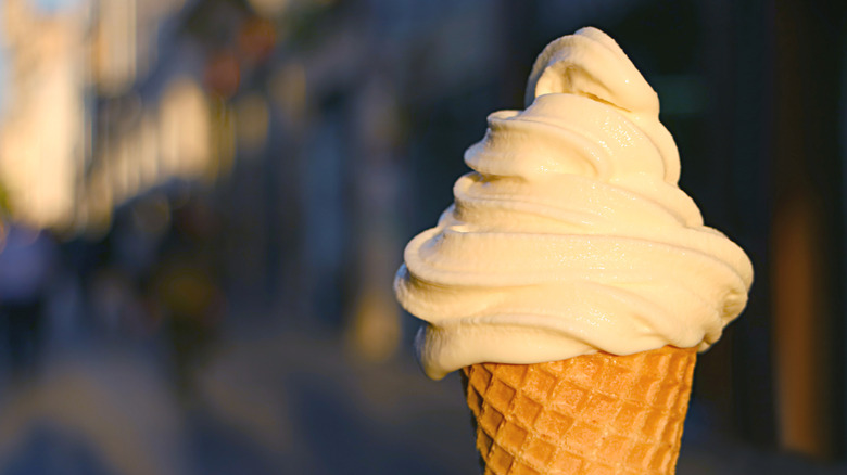 A close-up of vanilla ice cream in a cone in the setting sun