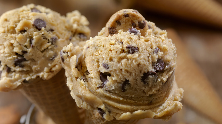 Two Cookie Dough ice cream cones topped with a mini cookie