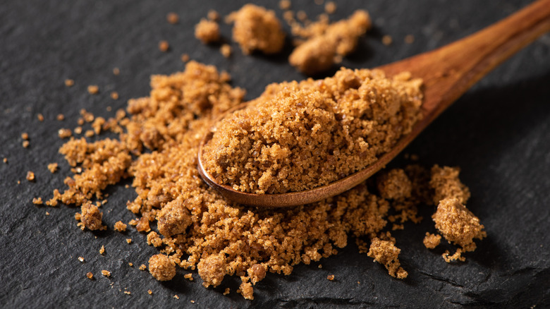 Spoonful of brown sugar on black background