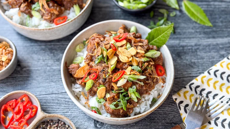 Filipino Pork Adobo in white bowls on a wooden table.