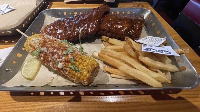Chili's baby back ribs served with Mexican street corn and french fries on a platter.
