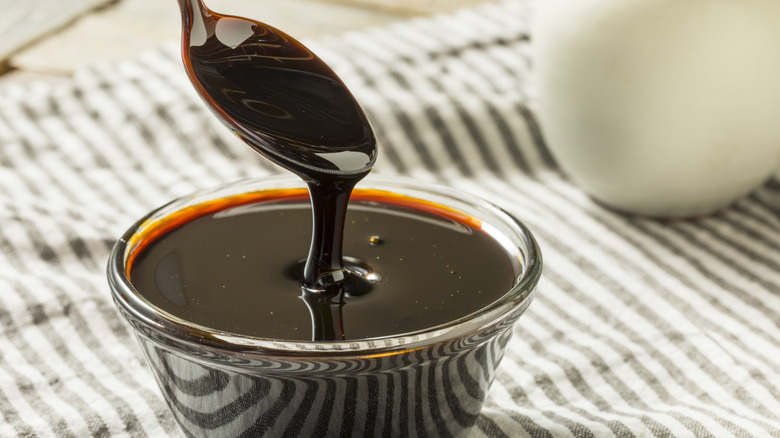 Glass bowl and spoonful of molasses