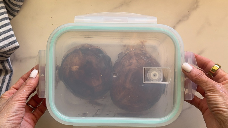 hands covering container with mushrooms