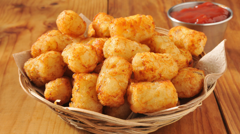 A basket of tater tots with ketchup on the side