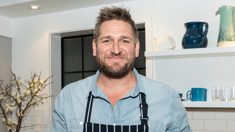 Curtis Stone smiling in a kitchen