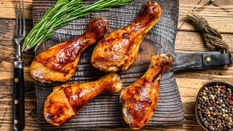 Barbecue chicken legs on a cutting board.