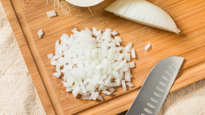 Chopped onions on cutting board.