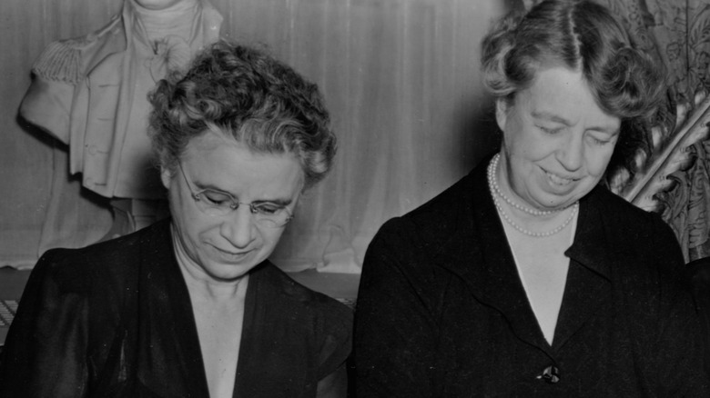 Black and white of Eleanor Roosevelt and Henrietta Nesbitt both looking down.