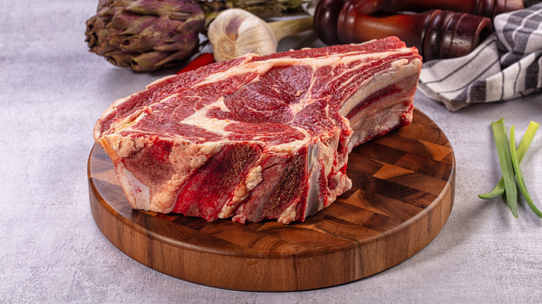 Uncooked bone-in prime rib on a wooden board