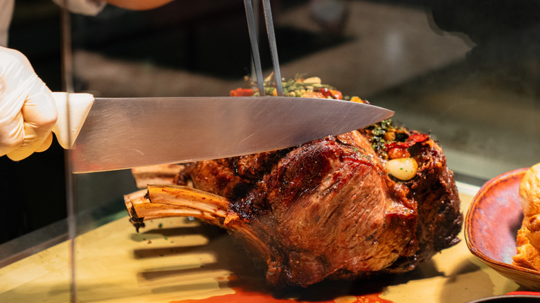 Chef slicing a standing rib roast.