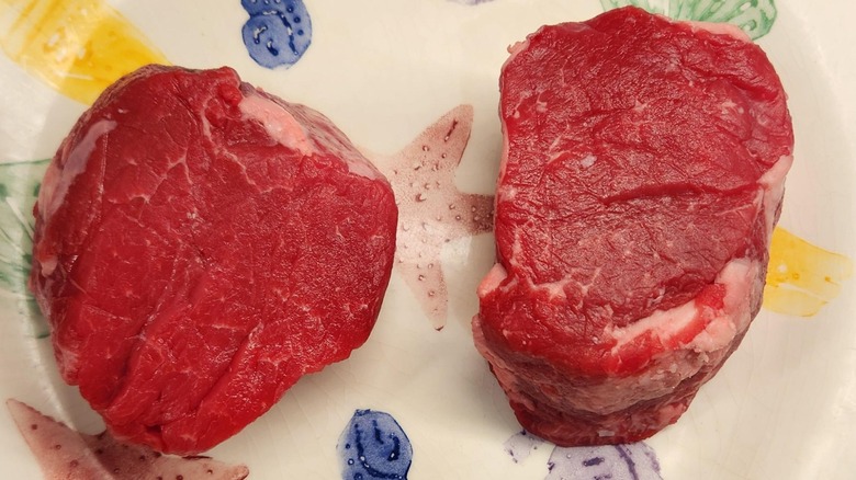 two choice beef tenderloin steaks raw on a plate