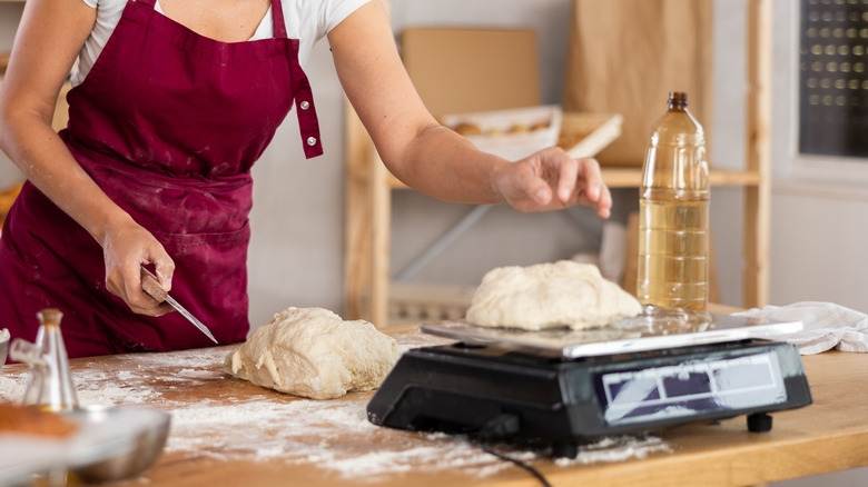Baker weighing dough on a kitchen scale