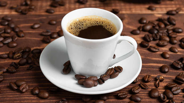 black coffee in a white ceramic mug with saucer