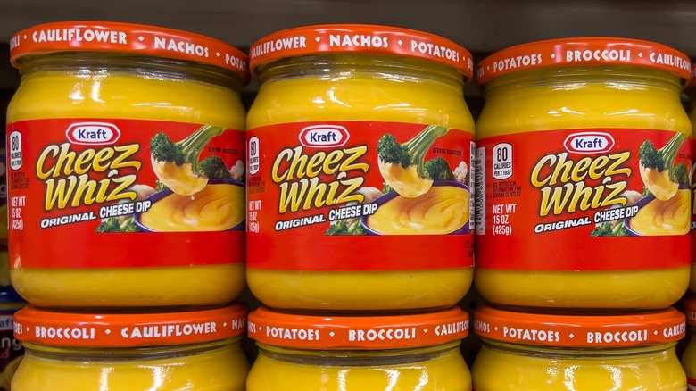 Tiga toples kaca Cheez Whiz di rak toko.