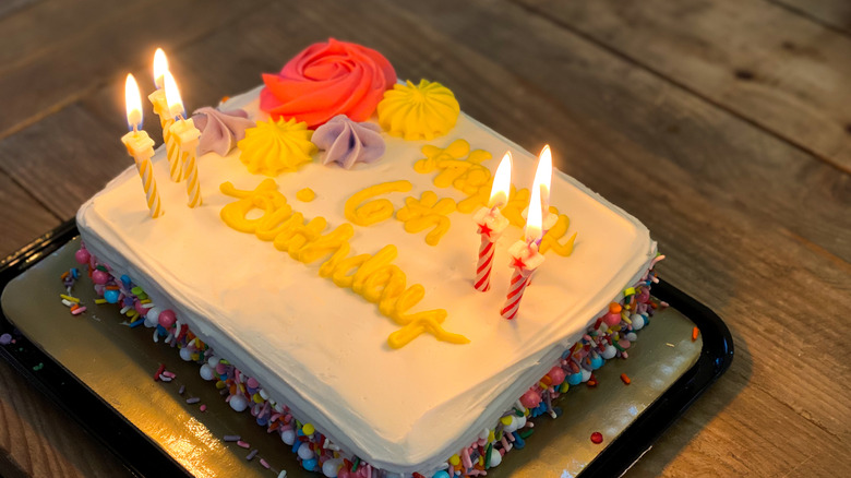 A sheet cake decorated with frosting and birthday candles