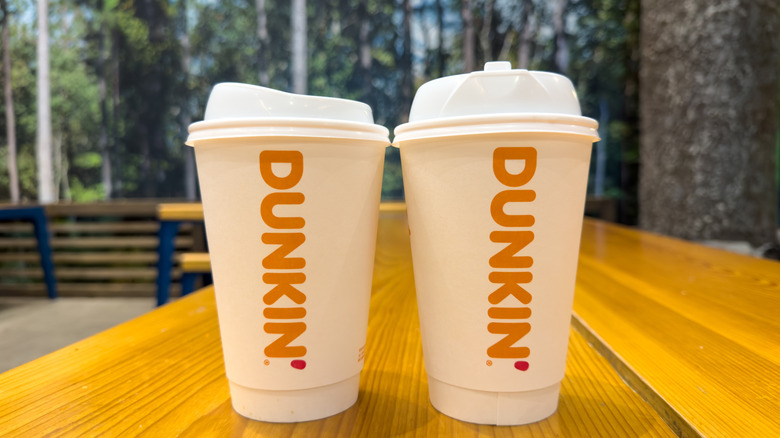Dunkin' cups on a table outside