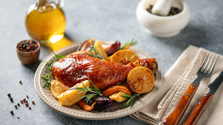 Roasted chicken with vegetables and herbs on a white plate
