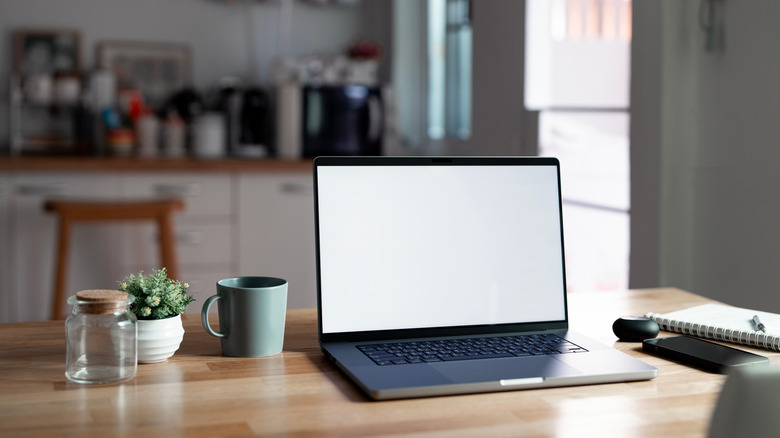 A laptop on a desk in a kitchen