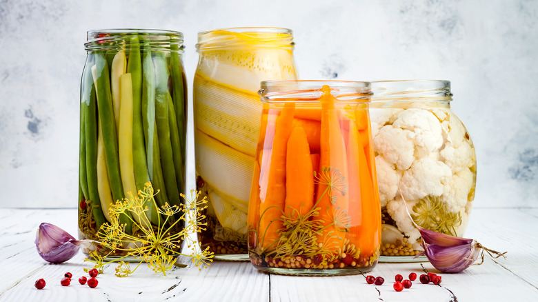 marinated pickles in a variety of jar shapes