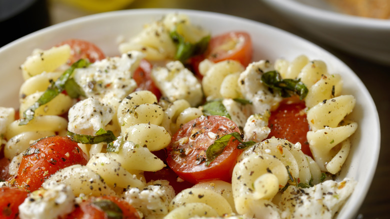 pasta salad in bowl with tomatoes 