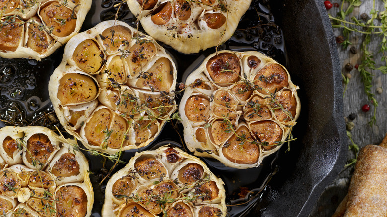 A skillet with roasted garlic bulbs