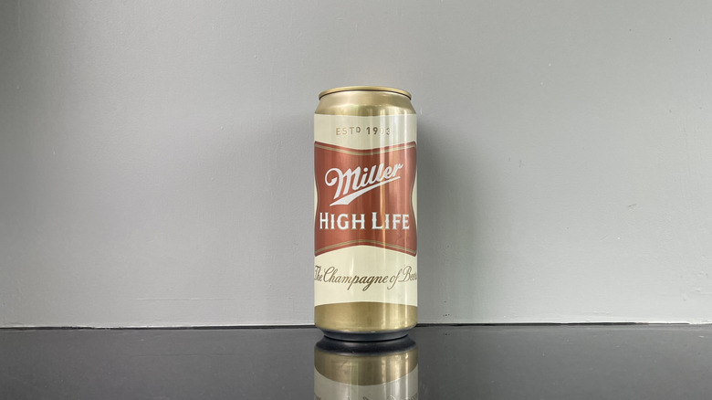 A tall boy of Miller High Life on dark table