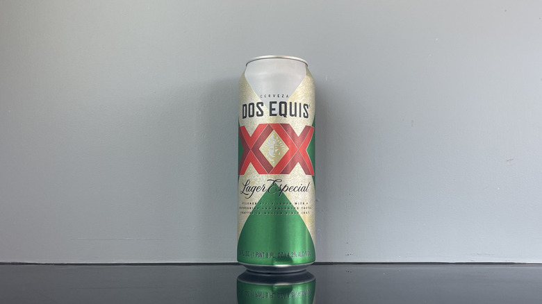 A tall boy of Dos Equis on dark table