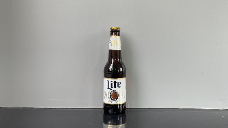 A bottle of Miller Lite on dark table