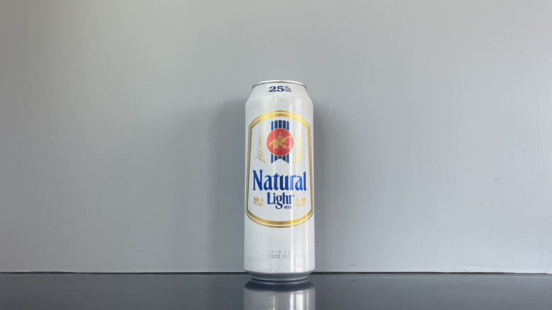 A tall boy of Natural Light on dark table
