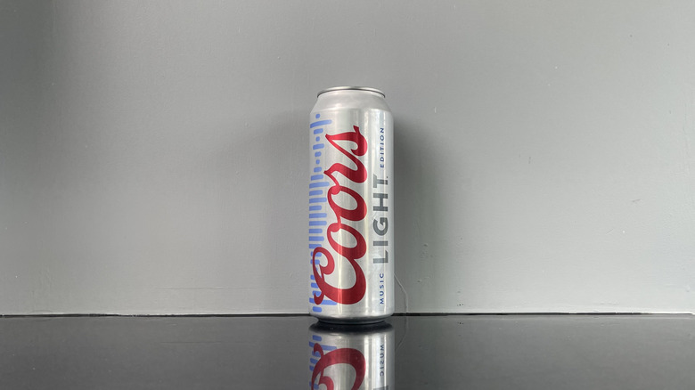 A tall boy of Coors Light on dark table