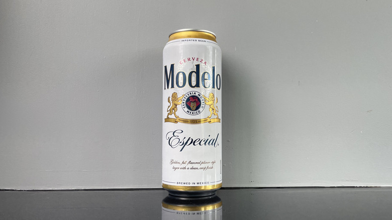 A tall boy of Modelo on dark table