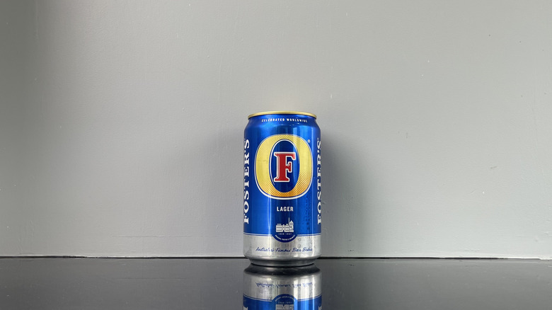 A Foster's oil can shaped beer on dark table