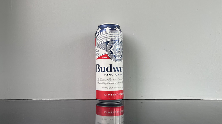 A tall boy of Budweiser on dark table