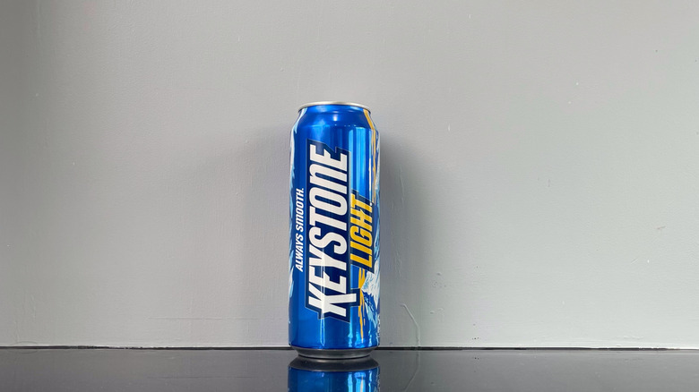 A tall boy of Keystone light on dark table
