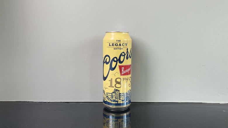 A tall boy of Coors Banquet on dark table