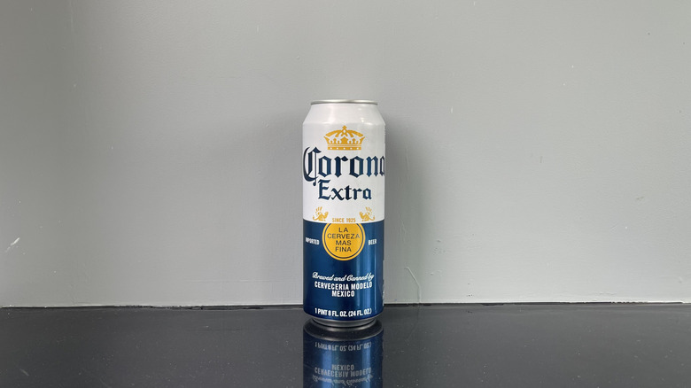 A tall boy of Corona on dark table