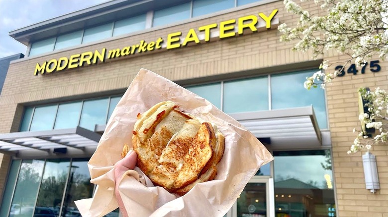 Hand holding Modern Market Eatery's Kid Grilled Cheese Dipper in front of store