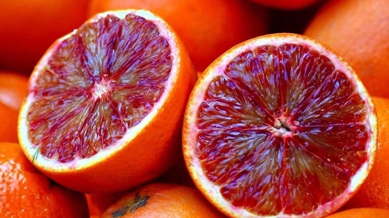 Halved and whole raspberry oranges