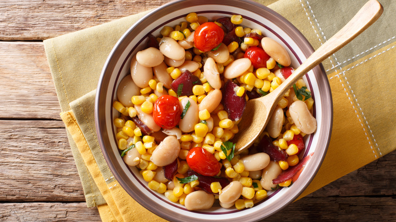 Bowl of lima bean salad on a wooden table surface