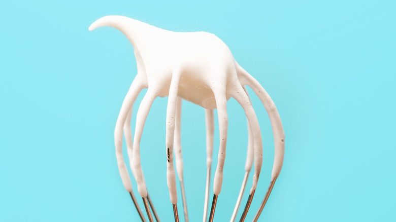silver whisk on blue background 