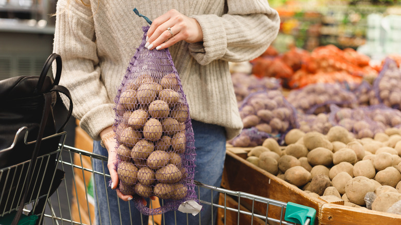 Woman picking potatoes at market