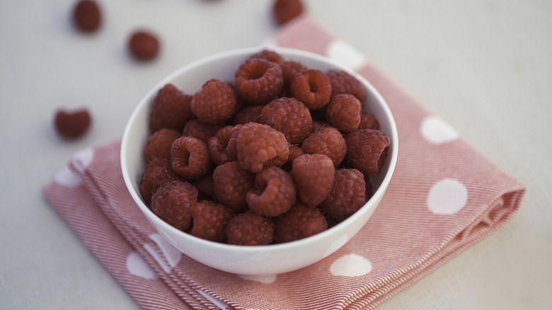 Bowl of rasperries on a polka dot napkin