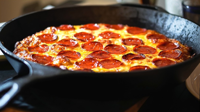 Fully-cooked pepperoni and cheese pizza in a cast iron pan