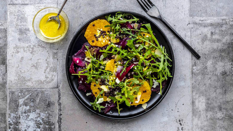 arugula salad with citrus elements and side of vinaigrette