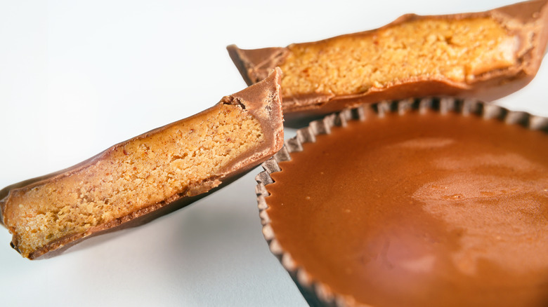 Close-up shot of peanut butter cups whole and cut in half isolated on white background