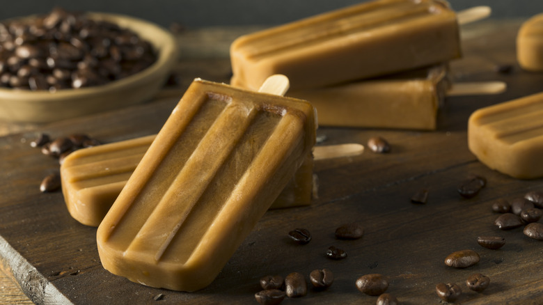 Coffee popsicles on a stick with coffee beans in background