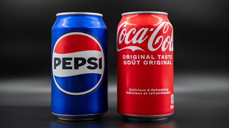 Can of Pepsi next to can of Coca-Cola